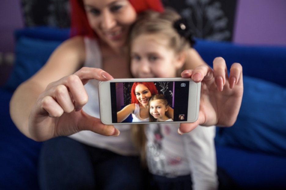 Mother and daughter using a smartphone app to conduct digital ethnography at home.