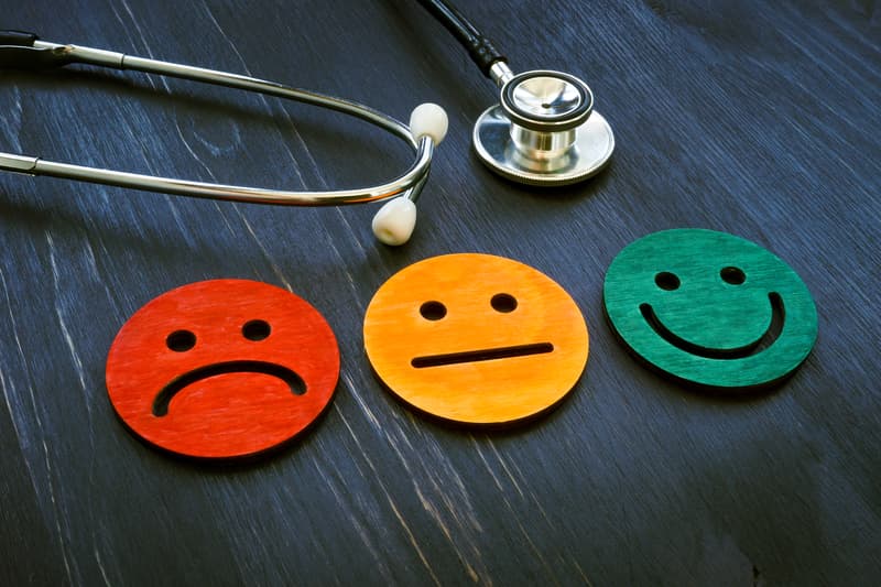 Three emoticon faces - frowning, neutral, and smiling, each representing varying patient satisfaction levels along a journey map