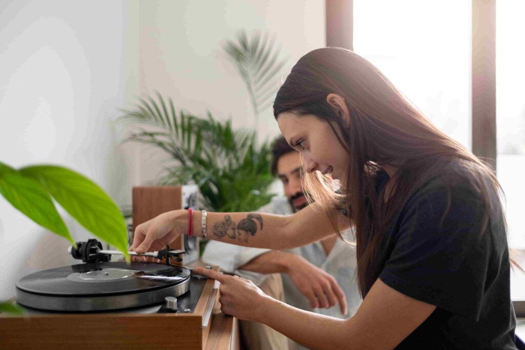 A man and woman relaxing and playing a vinyl record in their everyday life.